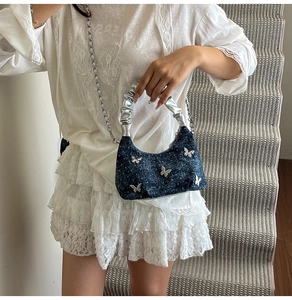 Sac sous le bras en denim bleu avec breloques papillon argentées et anse plissée