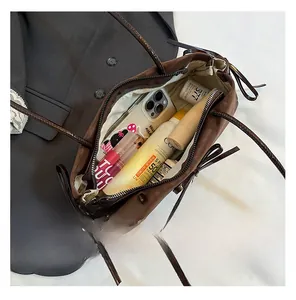 Top view of brown leather handbag interior showing storage capacity for phone and cosmetics