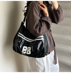 Close-up of black glossy sports tote bag with white stripes and number 85 embroidery