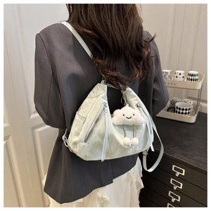 Detail view of mint green backpack with ruched texture and a cloud pendant charm