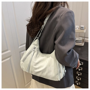Detail of light green crescent shoulder bag with soft pleated texture and silver zippers