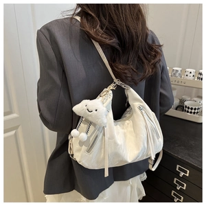 Detail of white hobo bag with cloud charm and silver zippers on a grey blazer outfit