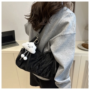 Detail of black pleated tote bag with silver zipper and cute white cloud charm