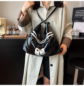 Close-up of black glossy patent leather tote featuring a white number 89 sports motif