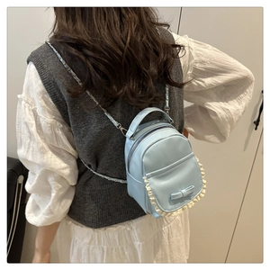 Détail du mini sac bleu clair avec nœud décoratif, bordure en dentelle et chaîne métal