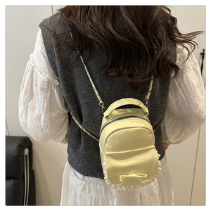 Détail du mini sac à dos jaune avec dentelle et nœud porté sur une tenue décontractée
