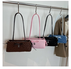 Detail of leopard print baguette bags with leather bows and heart charms in four colors