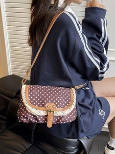 Vintage polka dot canvas crossbody bag with lace trim and brown leather strap on model