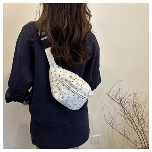 Corduroy crossbodytas met bloemenprint, bruine hartjes en strikjes op een model