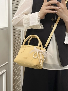 Elegant yellow bucket handbag with lace pearl bow charm and leather grain finish