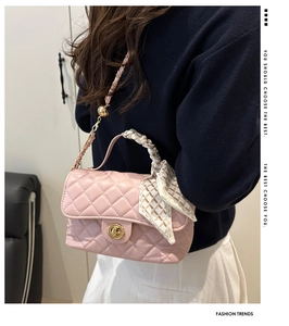 Detailed view of pink quilted handbag with gold turn-lock and silk scarf handle decor