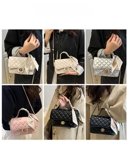Close-up of quilted crossbody bag with gold twist lock and silk scarf handle detail