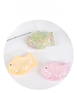 Detailed view of squishy carp stress toys in glittery and pearlescent soft textures
