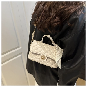 Detail of quilted beige handbag featuring gold turn-lock and elegant scarf handle wrap