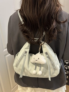 Versatile mint green nylon crossbody bag for women with cute cloud pendant on grey blazer