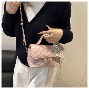 Close-up of pink quilted crossbody bag with silk scarf handle and gold chain strap