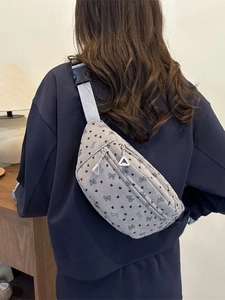 Grijze corduroy halve maan tas met strikjes, gedragen als een modieuze crossbody tas