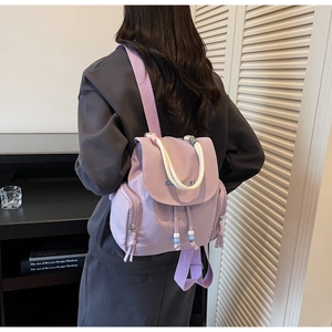 Detailansicht eines hellvioletten Nylon-Rucksacks mit Kordelzug und weißem Seilgriff