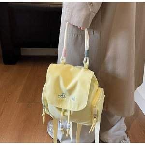 Detailansicht des gelben Canvas-Rucksacks mit Seilgriffen und Ai Mei Logo-Stickerei