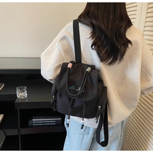 Details des schwarzen Nylon-Rucksacks mit Ai Mi Stickerei und buntem Kordelgriff