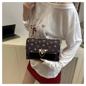 Detail of vintage floral mini crossbody bag with gold chain strap on female model