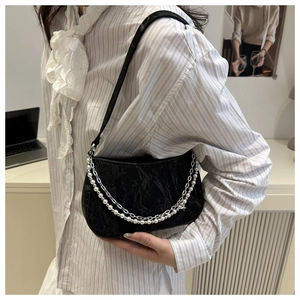 Detail of black pleated shoulder bag with white pearl and silver star metal double chains