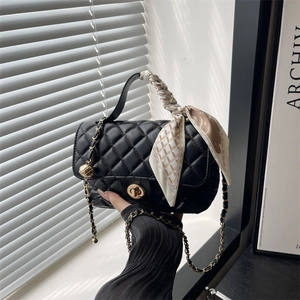 Quilted black crossbody bag with gold chain and silk scarf handle, elegant design