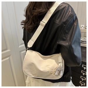 Detail of cream nylon crescent crossbody bag with adjustable wide strap and embroidery