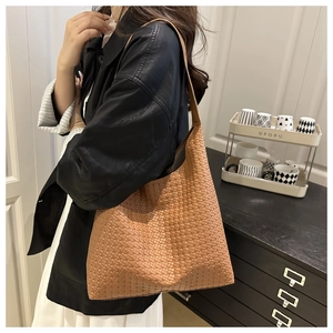 Detailed view of brown woven tote bag showing premium braided texture and spacious design