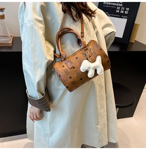 Détail du sac Boston marron vintage avec imprimé ours et breloque chiot sur modèle