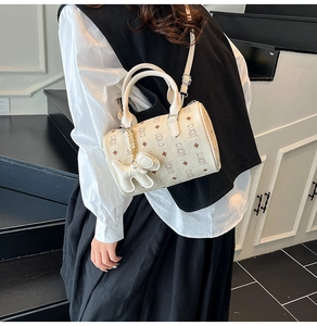 Détail du sac Boston avec motif d'ours et pendentif chien dans un décor de style de vie
