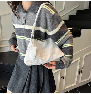 Détail d'un sac à bandoulière tressé blanc avec une petite pochette ronde assortie