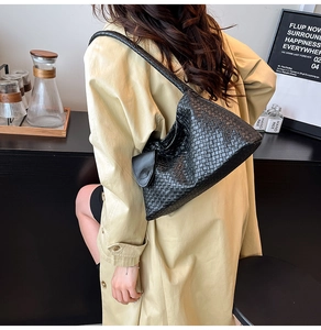 Détail du sac bandoulière en cuir tressé noir montrant les motifs géométriques précis