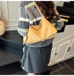 Détail du sac hobo tissé jaune montrant la texture et le mini porte-monnaie assorti