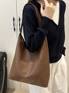 Brown woven leather hobo bag featuring a large capacity and stylish crossbody shoulder strap