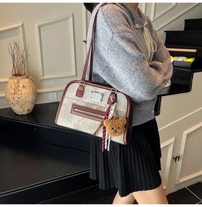 Détail du sac cabas rétro avec bordure en cuir brun, charm ourson et foulard en soie rayé