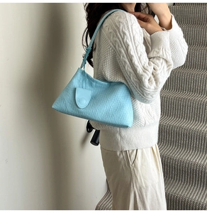 Detail of light blue woven texture faux leather shoulder bag with magnetic clasp