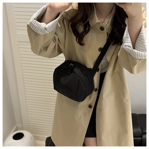 Close-up of black casual crossbody shell bag with double zippers on a model