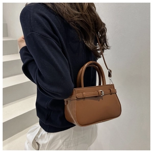 Rear view of a chic brown leather handbag with long handles and adjustable shoulder strap