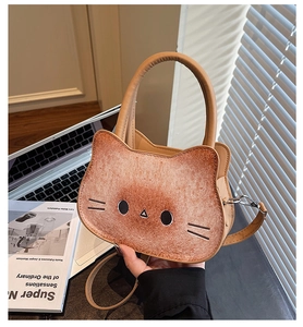 Detail of cute cat-shaped crossbody bag in toast brown color on a lifestyle desk setup