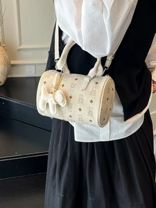 Sac Boston beige chic avec imprimé ours et breloque chien porté par un mannequin