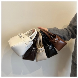 Close-up of five mini stylish crossbody bags in assorted colors with silver buckles