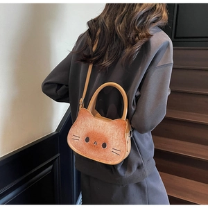 Detail view of cartoon cat-shaped toast bag showing caramel texture and crossbody strap
