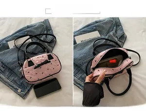 Détail de l'intérieur du sac Boston rose montrant l'espace pour téléphone et maquillage