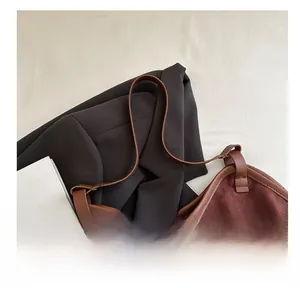 Detail view of burgundy suede tote bag with brown leather edges and comfortable handles
