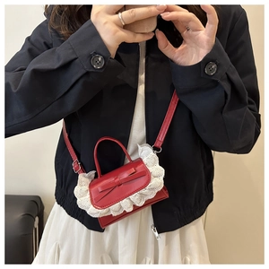 Detailansicht rote Mini-Handtasche mit weißer Spitze und Schleife am Outfit