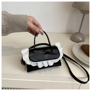 Detailansicht der schwarzen Ledertasche mit weißer Spitze und Schleifendekor