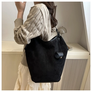 Detail of minimalist black suede tote bag showing soft matte texture and long shoulder straps