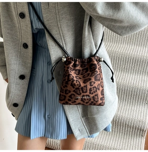 Détail du sac bandoulière léopard avec cordon de serrage et boucle argentée chic