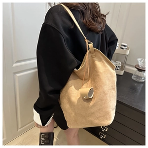 Détail de la texture en daim marron clair d'un sac à bandoulière chic de type seau